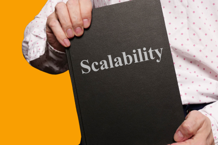 the-concept-of-scalability A person holding a book with the title “Scalability” on the cover.